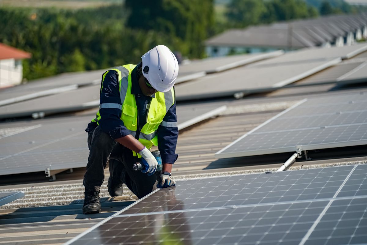 Technicien installant des panneaux solaires sur une toiture